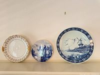 All three decorative plates on shelf