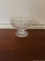 side profile of clear cut glass compote showing diamond pattern and pedestal