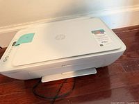 Full view top of white HP printer, lid closed