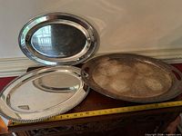 Three oval Sheffield silver-plated trays on table with tape for scale