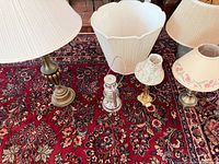 Group shot of lamps, shades and lantern on rug