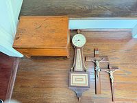 Top view of all items: wooden bench, banjo clock, two crucifixes