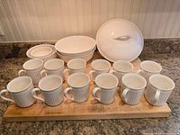 Front view showing 12 mugs, 4 bowls, casserole base and lid