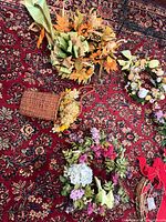 Group view showing wicker basket with autumn foliage, faux bouquet and red cardinal wreath
