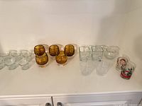 Full group of clear, amber, square, ribbed and printed votive holders