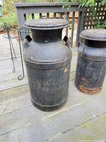 Large embossed black metal milk can, full view