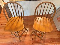 Two solid wood Windsor style bar stools front view