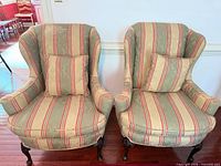 Front view of both wingback chairs showing upholstery pattern, overall design, and leg style