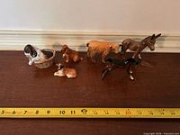 All six animal figurines lined with tape measure for scale