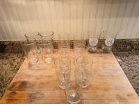 All fifteen glasses arranged on countertop showing logo and non-logo pieces