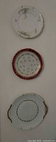 Three porcelain wall plates mounted vertically on wall