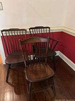 Three Windsor spindle-back chairs grouped together showing overall style and finish