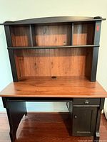 Front view of desk with hutch showing shelving, desktop, drawer and cabinet