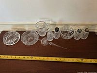 All nine cut crystal pieces lined with measuring tape for scale