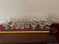 All sixteen Waterford glasses lined up with tape for scale