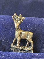 Front view of small 800 silver deer finial resting in case