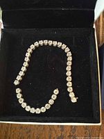 Bracelet laid in box showing overall design and broken state