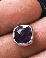 Cushion amethyst bezel showing facets and silver frame