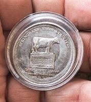 Obverse of coin showing cow monument and inscriptions