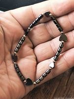 Bracelet displayed in hand showing bead arrangement and hearts