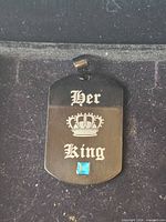 Front view of pendant showing text, crown motif and blue stone