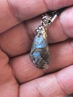 Close-up of labradorite pendant showing iridescent flash and metal cap
