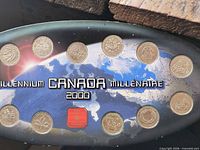 Front of oval display showing twelve 25-cent coins around world-map graphic