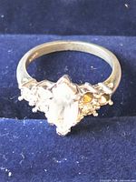 Front view of silver ring showing marquise clear stone and missing side stones