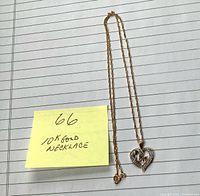 Full view of 10k gold necklace laid flat showing chain, pendant and clasp
