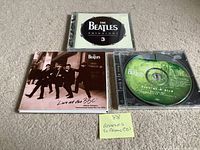 Front view of three Beatles promo CDs showing cover art and disc