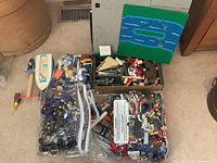 Overall lot showing boat hull, hammer accessory, two bags of loose LEGO, open box of bricks, baseplates