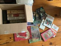 Entire lot showing box of books and additional books laid out on floor