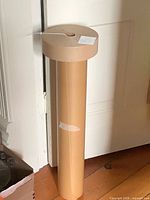 Butcher paper roll standing upright beside door with tape roll resting on top