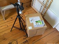 Tripod stand assembled beside boxed light kit and bulb package
