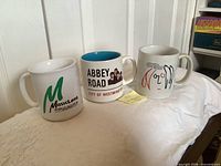 Front view of three mugs showing graphics