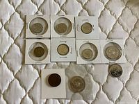 Assorted Canadian coins in flips and loose on quilted surface