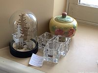 Group shot of three Nuvo glass candle holders, ceramic covered dish, and glass deer dome on windowsill