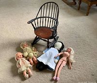 Overall lot showing wooden rocker and four dolls