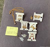 Group shot showing all earring pairs, pendants and necklace on display cards