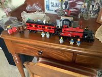 Overall view of assembled locomotive, coach, minifigures and bagged Fluffy figure on table
