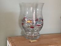 Full view of large clear vase on wooden surface