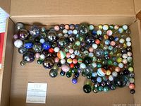 Full lot of assorted marbles spread in box