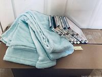 Light blue plush throw and stack of sealed The Lucy Show DVDs on box