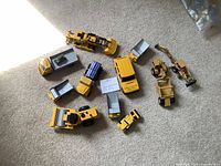 All 11 yellow die-cast construction vehicles arranged on carpet