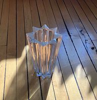 Oblique view of vase showing star rim and faceted sides on wood floor