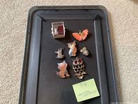 All seven animal jewelry pieces arranged on tray