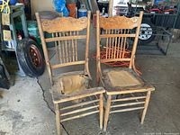 Two wooden press back chairs in garage setting