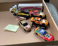 Top view of all vehicles in box showing race cars, display bases, transporter, hauler and yellow car