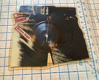 Front view of jean-shaped picture disc showing Brown Sugar text and centre spindle