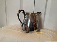 Right side view of silver-plated pitcher showing overall form and feet